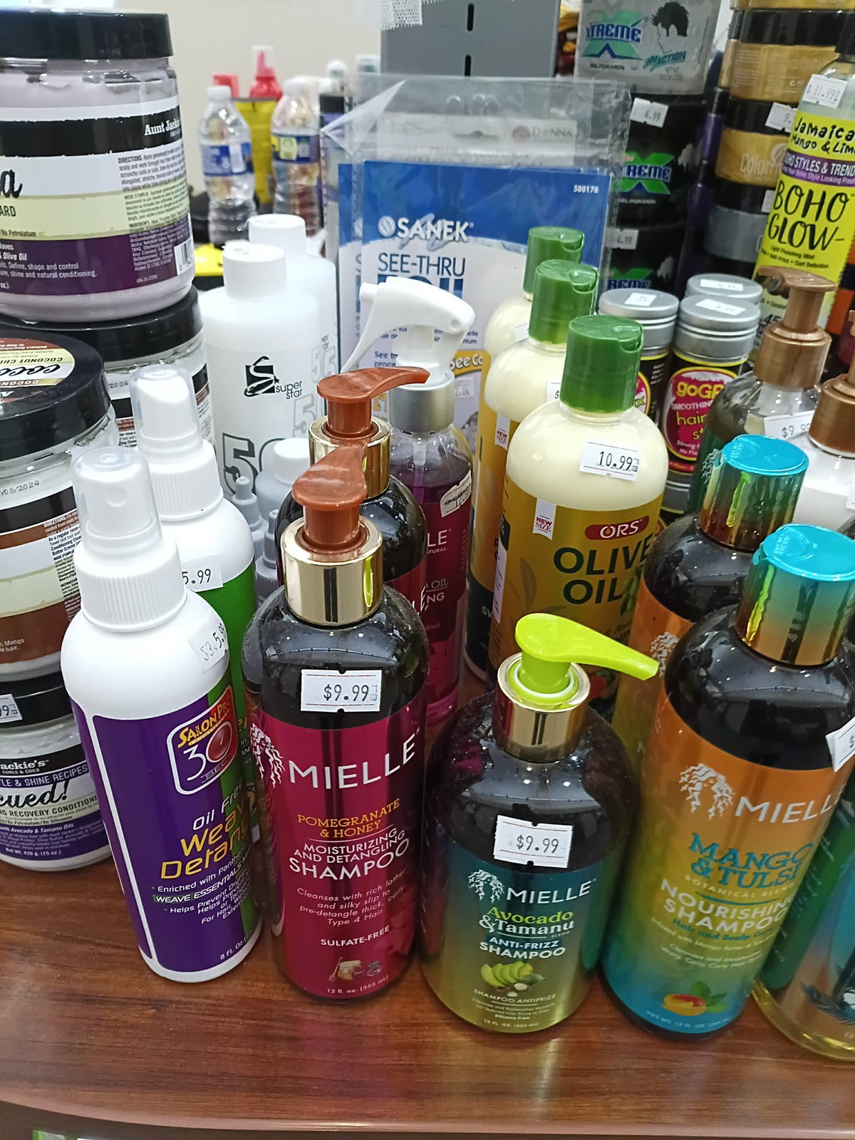 Mielle, Shea Moisture and other hair care bottles on a shelf at the kiosk