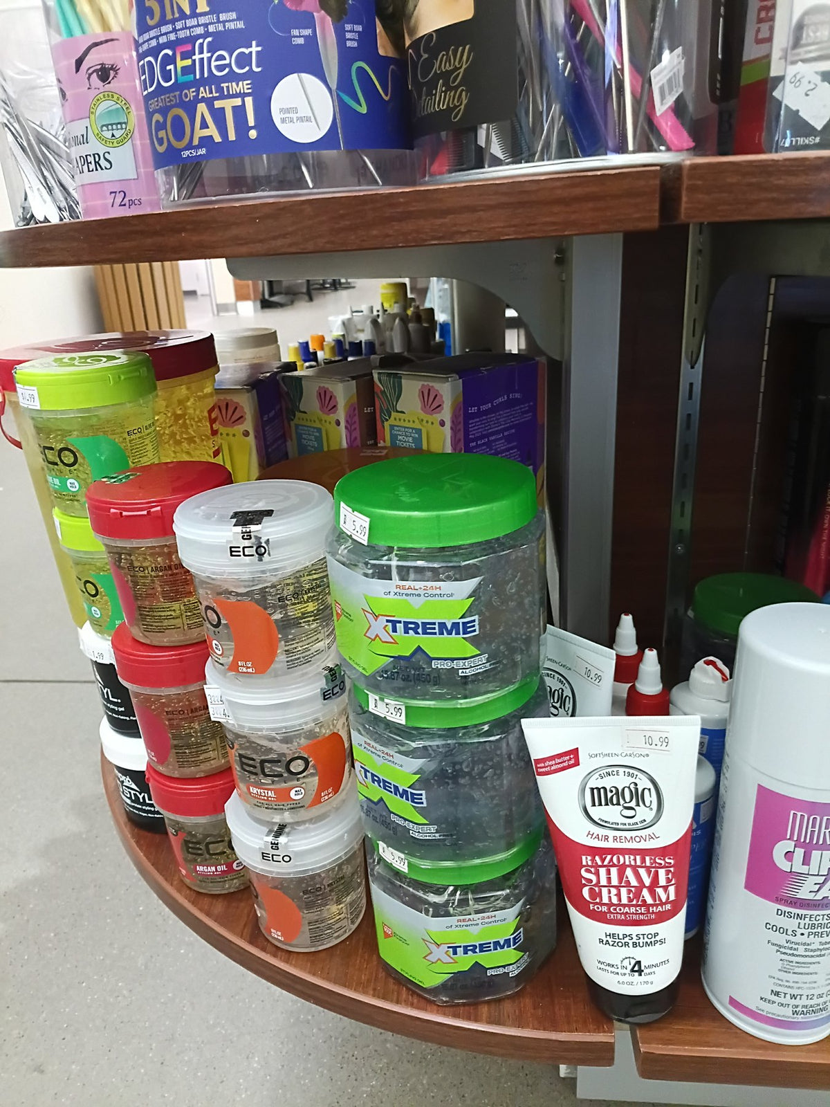 Hair gels and conditioners on a curved shelf at the Adele's Beauty Supply kiosk